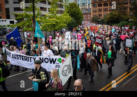 Manchester, Großbritannien. Oktober 2023. Demonstranten mit spruchbändern marschieren auf die Konferenz zu. Tausende von Menschen marschieren während der Konservativen Partei-Konferenz durch die Stadt, um eine nationale Demonstration durchzuführen. Die Forderungen, die von der Volksversammlung organisiert und von Gewerkschaften unterstützt werden, umfassen die Beendigung der Lebenshaltungskrise und die Verteidigung des NHS. Andy Barton/Alamy Live News Stockfoto