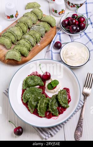 Hausgemachte Kirschknödel (Pierogien) mit Kirschsauce. Stockfoto