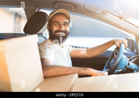 Fröhlicher Arabischer Fahrer, Der Im Automobil Mit Paketen Sitzt Stockfoto