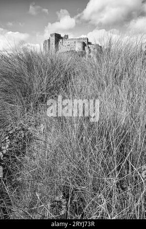 Bamburgh Castle an der nordöstlichen Küste Englands in Northumberland von den Sanddünen am Ufer aus gesehen. Stockfoto