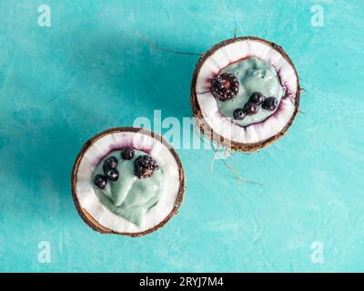 Zwei coconut Hälfte spirulina Smoothie auf blauen Tabelle Stockfoto