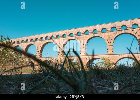 Das dreistufige Aquädukt Pont du Gard wurde in römischer Zeit am Fluss Gardon errichtet. Sommertag in der Provence. Blick vom Boden. Stockfoto