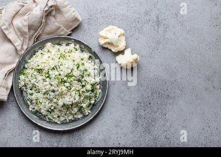 Roher Blumenkohlreis oder Couscous mit Dill auf Teller, gesunde kohlenhydratarme Gemüsebeilage für Keto-Diät und gesunde Low Stockfoto