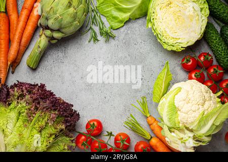 Frisches Bio-Gemüse auf rustikalem grauem Steintisch mit Kopierraum. Vegetarische Lebensmittel Hintergrund und gesund ve Stockfoto