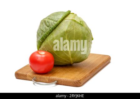 Tomate und Kohl auf dem Holzschneidebrett. Stockfoto