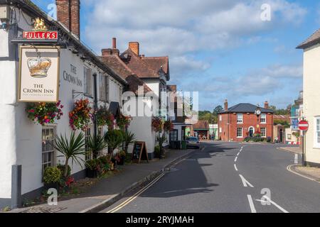 Das Crown Inn Pub in Bishops Waltham, Hampshire, England, Großbritannien, mit Blick auf die Uhr am St. Georges Square Stockfoto