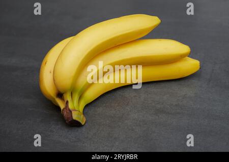 Nahaufnahme von Bananen auf einem schwarzen Brett Stockfoto