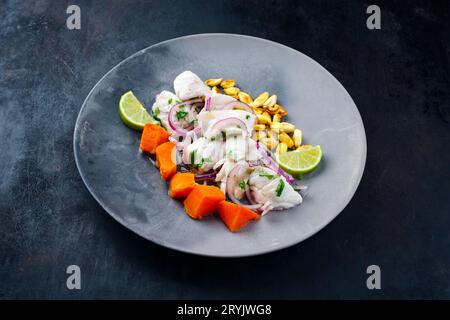 Traditionelles peruanisches Gourmet-Ceviche-Seebarschfilet mit Süßkartoffeln und Cancha mariniert und in Limettensauce serviert als C. Stockfoto