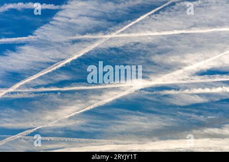 Mehrere Kondensstreifen am frühen Morgenhimmel auf vielbefahrenen Verkehrsflugstrecken über Zentralfrankreich. Stockfoto