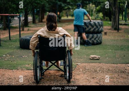 Behinderte Frau, die im Rollstuhl im Park sitzt. Hochwertige Fotos Stockfoto