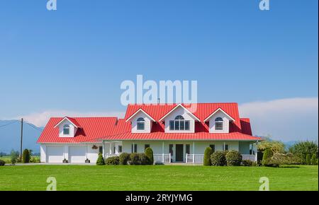 Bauernfamilienhaus mit doppelter Garage und grünem Rasen davor Stockfoto