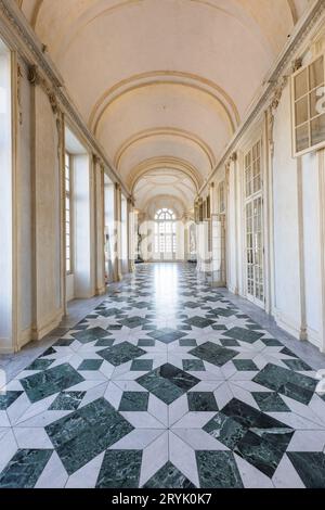 Venaria reale, Italien - Januar 2023: Luxuriöser Innenraum des alten Königspalastes. Galerieperspektive mit Fenster. Stockfoto