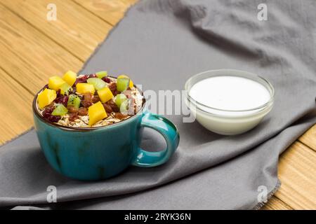 Müsli ausgewogenes Protein-Frühstück. Früchte Beeren Samen Kokosnussjoghurt. Gesunde Ernährung vegetarische Ernährung. Flach liegend. Holzhintergrund. Leerzeichen kopieren Stockfoto