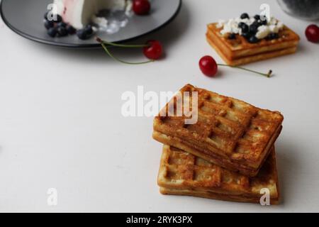 Das Frühstück war lecker. Snack zwei weiche belgische Waffeln liegen übereinander neben Heidelbeeren Kirschkäse Hüttenkäse mit Platz für Text und Stockfoto