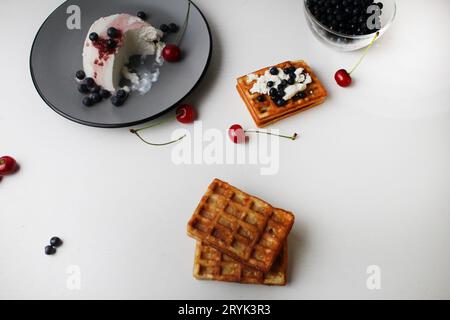 Das Frühstück war lecker. Snack zwei weiche belgische Waffeln liegen übereinander neben Heidelbeeren Kirschkäse Hüttenkäse mit Platz für Text und Stockfoto