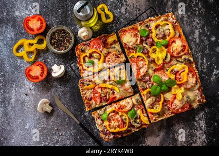 Hausgemachte Pizza im Detroit-Stil. Große rechteckige Peperoni-Pizza mit Pilzen, Salami und Käse auf einer Steinplatte. Bis Stockfoto