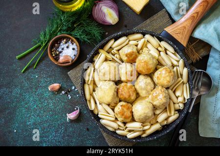Italienische Pasta. Spaghetti mit Fleischbällchen in Käsesauce auf dunklem Stein oder Beton. Draufsicht, flacher Hintergrund. Stockfoto