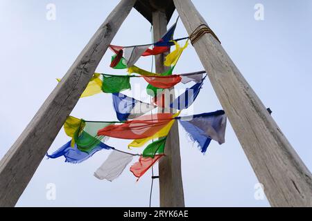 Tibetische Gebetsfahnen in Svycarna, Jeseniki-Berge, Tschechische Republik, Tschechien. Farbiges Tuch, aufgereiht auf Holzpfosten und -Pfosten. Die Fahnen wehen im Wind. Stockfoto