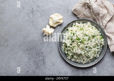 Roher Blumenkohlreis oder Couscous mit Dill auf Teller, gesunde kohlenhydratarme Gemüsebeilage für Keto-Diät und gesunde Low Stockfoto