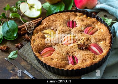 Apfelbäcken glutenfrei saisonal. Herbstkuchen mit Äpfeln, Haselnuss und Zimt auf einem Holztisch. Stockfoto