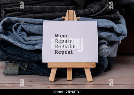 WIEDERKEHRENDER Text auf Papiernotiz zu Jeans-Bekleidungssortiment aus Second Hand für nachhaltiges Shopping. Kapsel minimal wardr Stockfoto