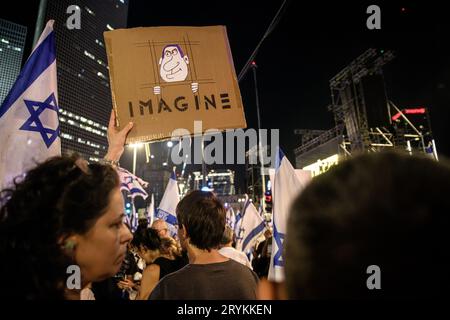 Israel. September 2023 30. Ein Demonstrant hält ein Zeichen mit einem Karikaturfilm, der Premierminister Benjamin Netanjahu hinter Gittern zeigt, auf dem während eines Protestes gegen die Justizreform „Imagine“ steht. Tel Aviv, Israel. 30. September 2023. (Matan Golan/SIPA USA). Quelle: SIPA USA/Alamy Live News Stockfoto