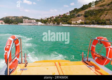 Rote Rettungsschwimmer hängen an einem sonnigen Tag an einem Geländer eines Rettungsbootes Stockfoto