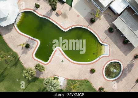 Drohnenantenne des verlassenen, verlassenen Hotelschwimmbades. Schmutziges Wasser verlassenes Hotel Stockfoto