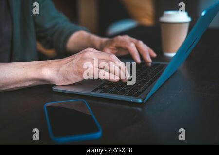 Nahaufnahme der Hände des Mannes, die eine Textnachricht auf der Tastatur des Laptops eingeben. Einrichtung von zu Hause aus und moderne Kommunikationstechnologie. Das mA Stockfoto