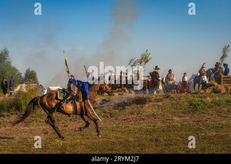 Verwundeter Soldat flüchtet auf einem Pferd auf einem Schlachtfeld. Historische Nachstellung der Schlacht von Gniew, polnischer schwedischer Krieg Stockfoto