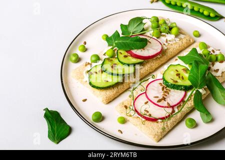 Gesunde Sandwiches mit Weichkäse und rohem Gemüse auf knusprigem Brot Stockfoto