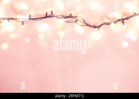 Gelbe Girlande auf rosafarbenem Hintergrund. Weihnachtskonzept Stockfoto