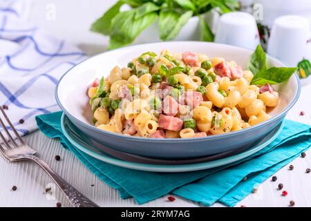 Hausgemachte Pasta mit grünen Erbsen und Schinken aus nächster Nähe. Stockfoto