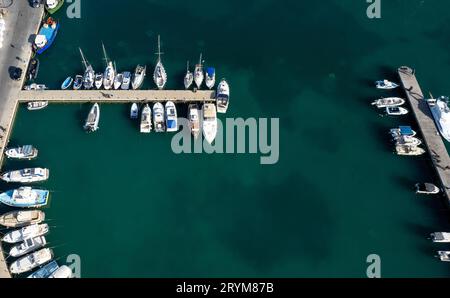 Drohnenlandschaft eines Fischereihafens. Fischerboote und Yachten liegen im Hafen vor Stockfoto