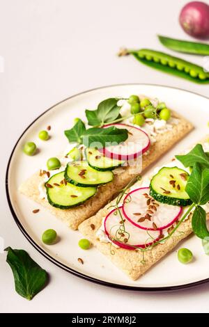 Gesunde Sandwiches mit Weichkäse und rohem Gemüse auf knusprigem Brot Stockfoto