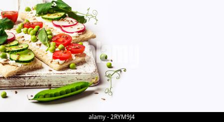 Gesunde Sandwiches mit Weichkäse und rohem Gemüse auf knusprigem Brot Stockfoto