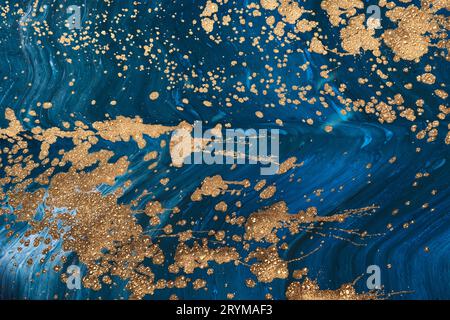Flüssige Art Acrylfarben. Abstrakte Mischung von blauen Farbwellen. Flüssiges Gold fließt in Spritzer. Hintergrund oder Textur mit Marmoreffekt Stockfoto