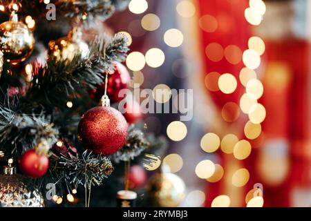 Nahaufnahme von Kugeln auf weihnachtsbaum. Bokeh Girlanden im Hintergrund. Neujahrskonzept. Stockfoto