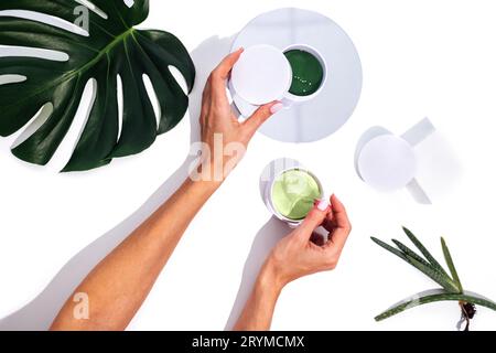 Nahaufnahme von gut gepflegten weiblichen Händen mit schöner Maniküre-Haltebox mit grünen Flecken Stockfoto