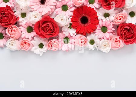 Die florale Zusammensetzung von Rosen und Gerberas auf grauem Hintergrund. Anordnung schöner Blumen Stockfoto