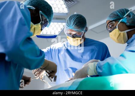 Vielfältige Chirurgengruppe, die Patienten im Operationssaal operiert Stockfoto