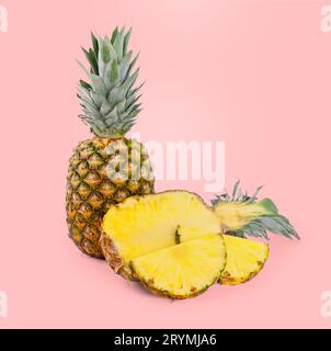 Geschnittene und ganze Ananas auf rosafarbenem Hintergrund Stockfoto