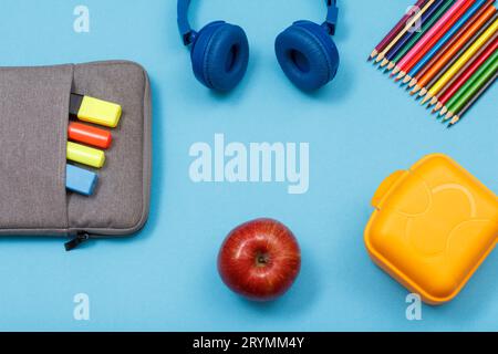 Lunchbox, Farbstifte, ein Apfel, Kopfhörer und Tasche-Bleistiftetui mit farbigen Filzstiften Stockfoto