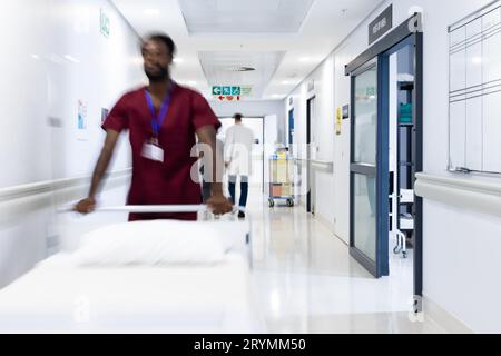 Verschwommene Bewegung von verschiedenen Ärzten und medizinischem Personal im belebten Krankenhausflur, Kopierraum Stockfoto