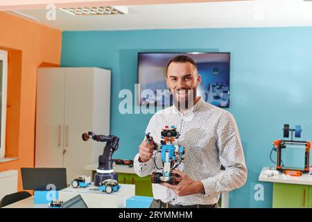 Ein Mann, der in einem Robotiklabor arbeitet und sich auf die komplexen Bereiche Robotik und 3D-Druck konzentriert. Zeigen Sie ihr Engagement Stockfoto