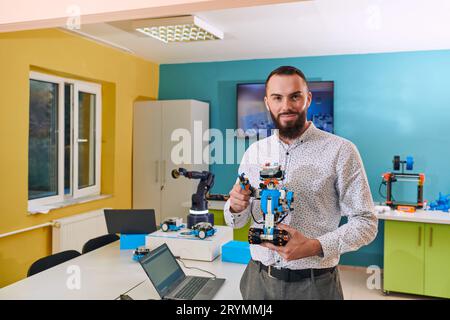 Ein Mann, der in einem Robotiklabor arbeitet und sich auf die komplexen Bereiche Robotik und 3D-Druck konzentriert. Zeigen Sie ihr Engagement Stockfoto