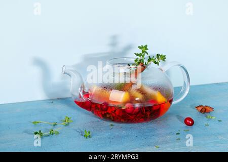 Immunitätssteigerungsgetränk. Wintertee mit Preiselbeeren, Orangen, Hibiskus und Gewürzen in einer Teekanne aus Glas Stockfoto