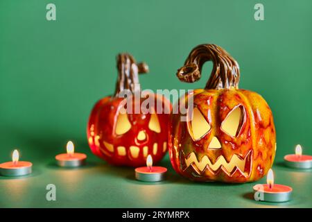 Halloween Komposition mit diy Keramik Kürbisse Jack Laterne und Kerzen auf Kieferngrünem Hintergrund Stockfoto