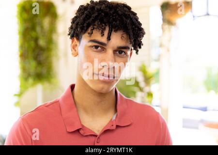 Nahaufnahme eines birassischen jungen Mannes mit Dreadlocks, der zu Hause ernsthaft in die Kamera schaut, Kopierraum Stockfoto