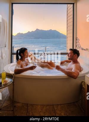 Paare in einer Badewanne mit Blick auf das Meer von Kapstadt Südafrika während des Urlaubs Stockfoto